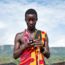 Young Masai male checks mobile device.